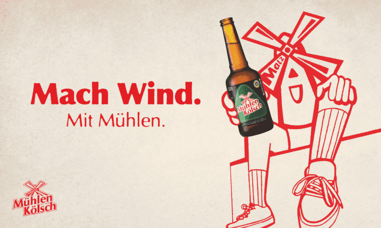 Mühlen Kölsch Kampagne Mach Wind mit Mühlen - Emühlio prostet mit Kölschflasche an